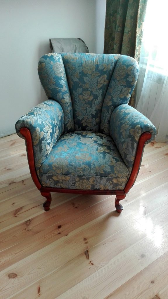 Krzesło tapicerskie na drewnianej podłodze w pokoju.