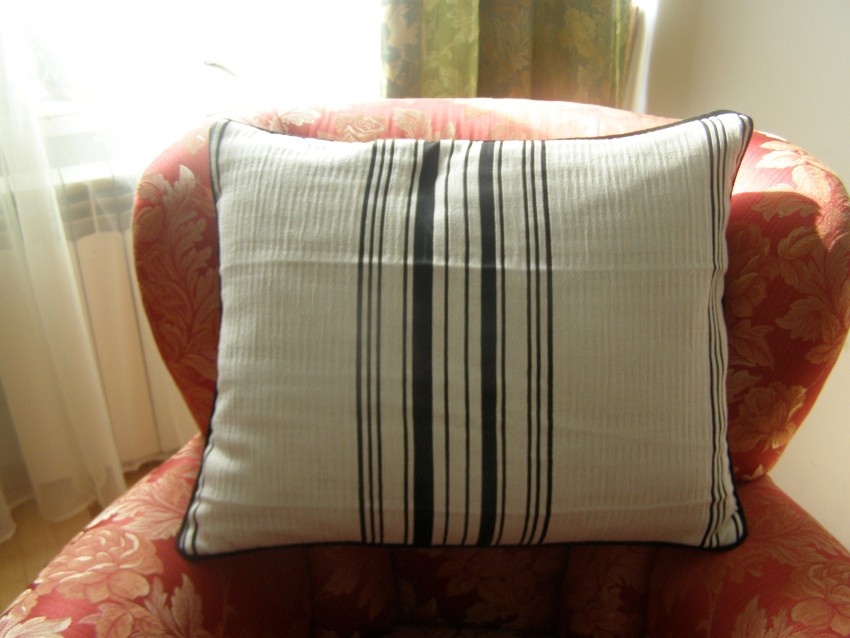 Fotel tapicerski z poduszką w paski.